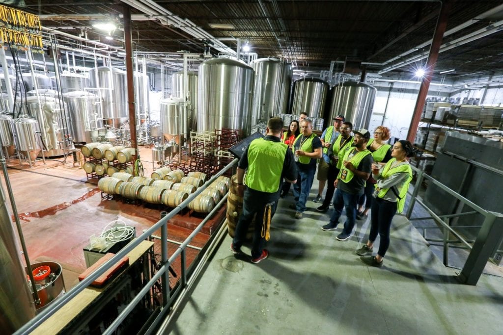 Baltimore tour group with guide in the production area of a local brewery