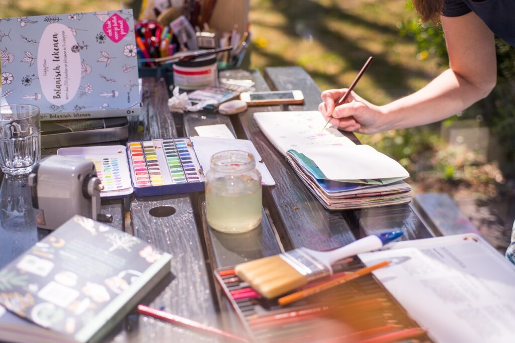 Outdoor creative session with watercolor paints, sketchbooks, and art supplies, ideal for a relaxing and artistic activity during a bachelorette party.