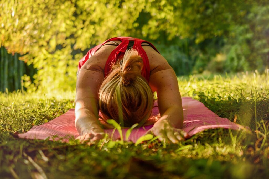 Relaxing outdoor yoga session on a pink mat, perfect for a calming and refreshing activity during a bachelorette party weekend.