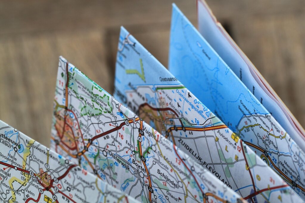 Close-up of folded maps, ideal for planning an adventurous road trip or exploring a new city during a bachelorette party.
