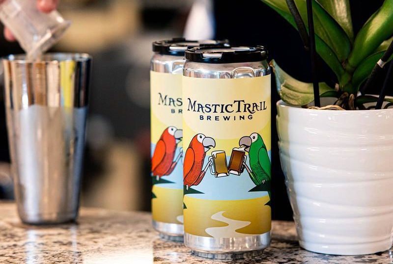 Mastic Trail Brewing beer cans sit on bar top.